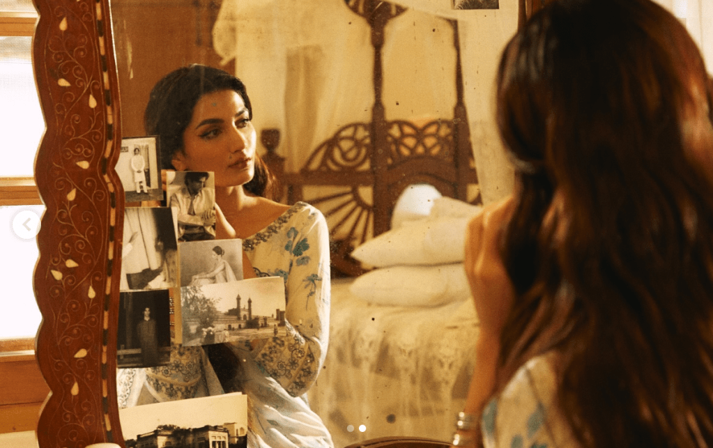 Woman looking in the mirror with vintage postcards and images stuck on it.
