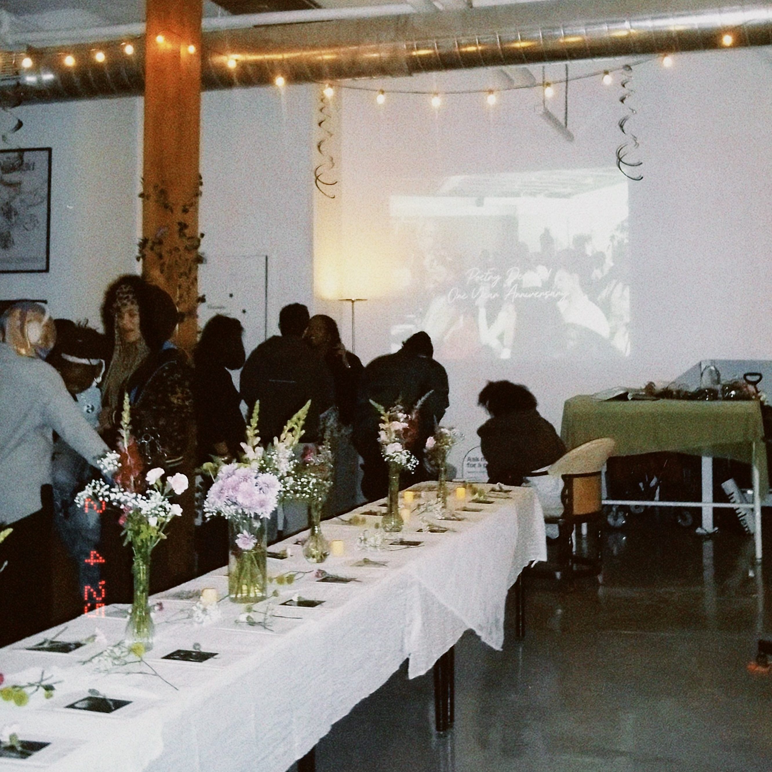A table stands with flowers and letters placed on it.
